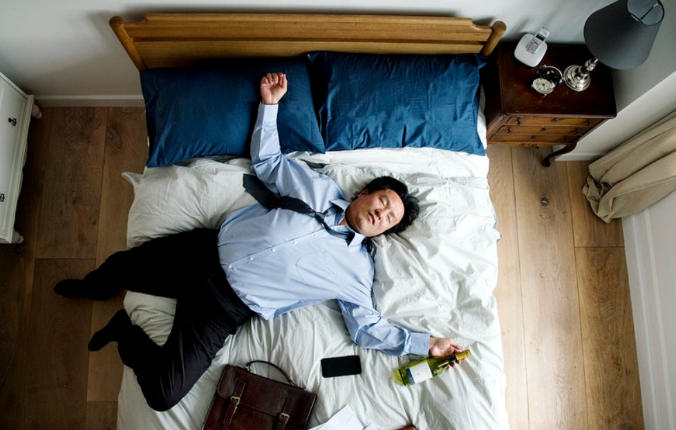 tired business man lying on bed